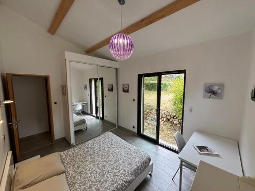 une chambre avec un lit, une table et une lampe rose dans l'établissement Lei Bancaou, à Roquevaire