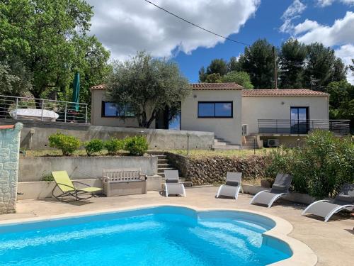 une piscine avec des chaises et une maison dans l'établissement Lei Bancaou, à Roquevaire