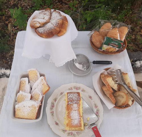 a table with bread and pastries and plates of food at B&b il Giardino del Barone in Pozzomaggiore