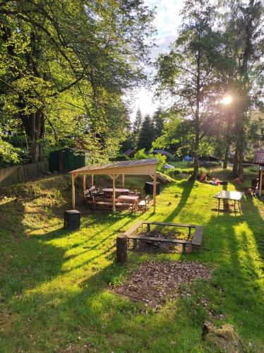 a park with a picnic table and a pavilion in the grass at Lesní chaty "Hogo Fogo" in Kytlice