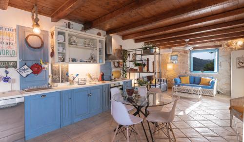 a kitchen with blue cabinets and a table in a room at Casa Picimenti Zakynthos Marathias Swimming Pool Ground Floor Villa in Marathias