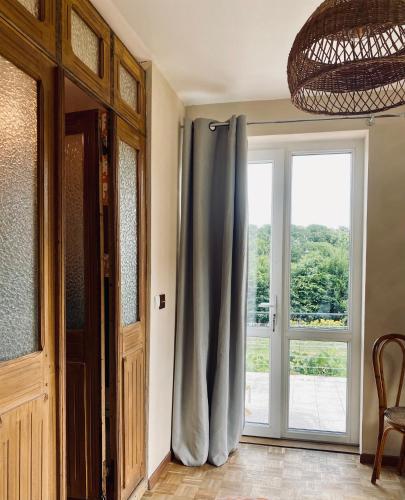 a room with a door and a window with a curtain at Maison La folie douce in Saint-Pierre-de-Manneville