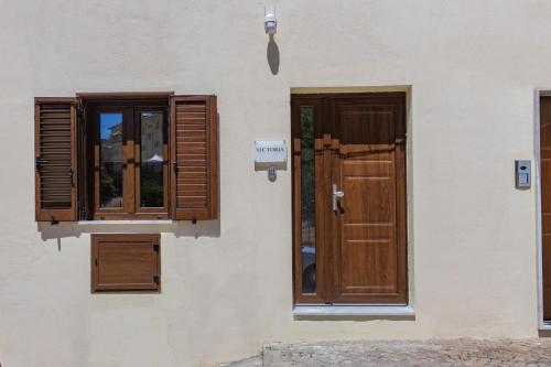 a building with wooden doors and windows on it at B&B Victoria in Laurenzana