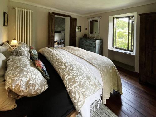 a bedroom with a bed with a white comforter and a window at Stone Oven House in Rorá