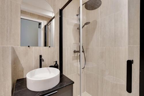 une salle de bain avec un lavabo et une douche dans l'établissement La Maison Bizot 43 T3 by ecoflats, à Paris
