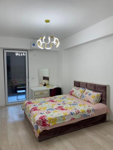 a bedroom with a bed and a chandelier at E&M Apartman in Struga