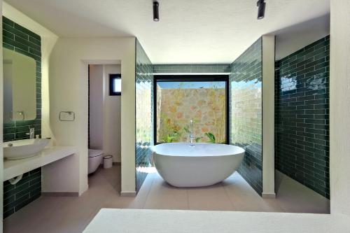 a bathroom with a tub and two sinks and a window at Inn Villas in Fethiye