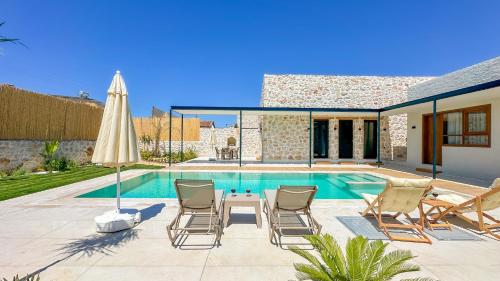 a patio with a pool and chairs and an umbrella at Inn Villas in Fethiye