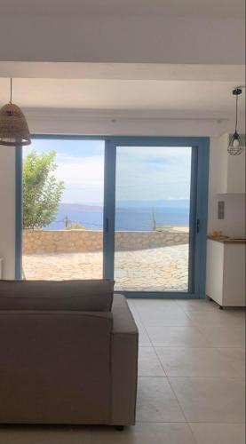 a living room with a couch and a view of the beach at Heavenly View Peach in Lákhion