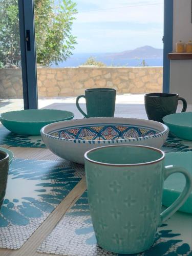 a table with two cups and a plate on it at Heavenly View Peach in Lákhion