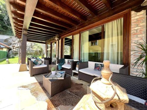 an outdoor patio with couches and tables and windows at Secret Paradise, Stylish Host in Camargo
