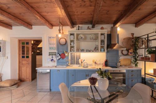 a kitchen with blue cabinets and a table and chairs at Casa Picimenti Zakynthos Marathias Swimming Pool Ground Floor Villa in Marathias