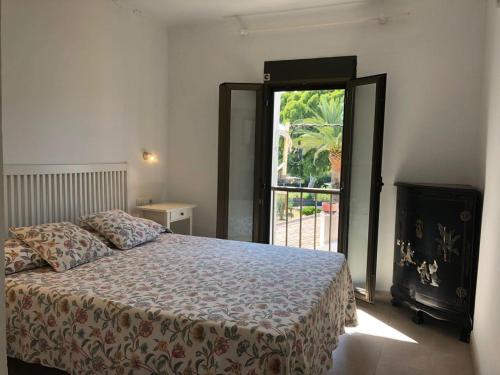 Un dormitorio con una cama y una ventana grande. en Altafulla, primera linea de mar con acceso directo a la playa, en Altafulla