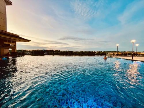a swimming pool with blue water in front of a building at Kuching City Center Riverine Apartment With Balcony and Marvelous View in Kuching