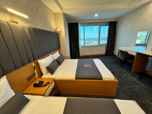 a hotel room with two beds and a desk at E5 PARK OTEL in Esenyurt
