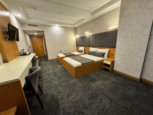 a hotel room with two beds and a desk at E5 PARK OTEL in Esenyurt