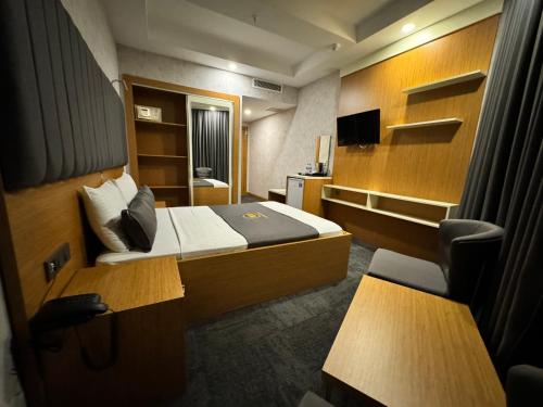 a small hotel room with a bed and a tv at E5 PARK OTEL in Esenyurt