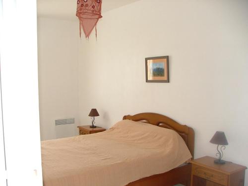 une chambre avec un lit et deux tables de nuit avec lampes dans l'établissement maisons 6 personnes Royan piscine couverte, à Saint-Georges-de-Didonne