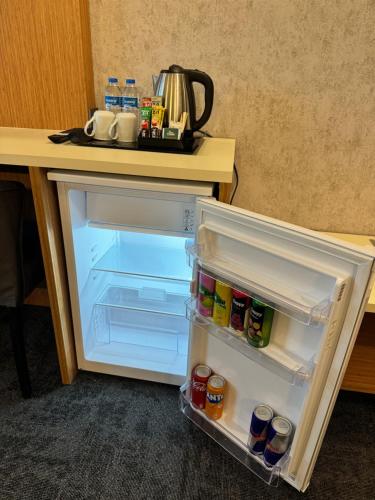 an open refrigerator sitting next to a table at E5 PARK OTEL in Esenyurt
