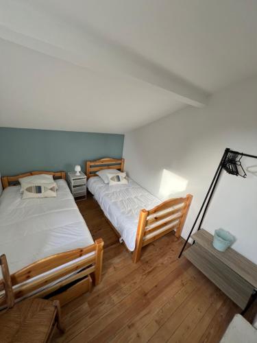 deux lits dans une chambre avec parquet dans l'établissement Maison 8 pers à 900 m de la mer au calme, à Vaux-sur-Mer