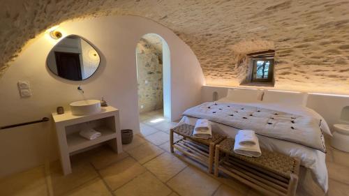 une chambre avec un lit, un lavabo et un miroir dans l'établissement Mas de Faviérette, gîte Les Voûtes et gîte La Terrasse, à Sabran