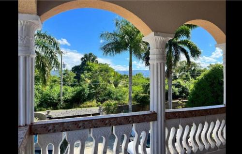 a balcony with palm trees and a view of the ocean at Indigo Beach Villa in Black River