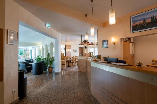 a kitchen and living room with a bar in a room at Airport Business Hotel Köln in Cologne