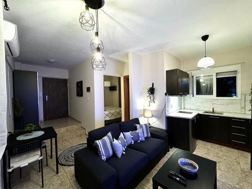 a living room with a blue couch and a kitchen at Sun Sight - Deluxe Infinity View Suites in Pefkochori