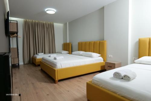a hotel room with two beds and a flat screen tv at Comfort Rooms Pogradec in Pogradec