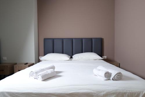 a white bed with two rolled towels on it at Comfort Rooms Pogradec in Pogradec