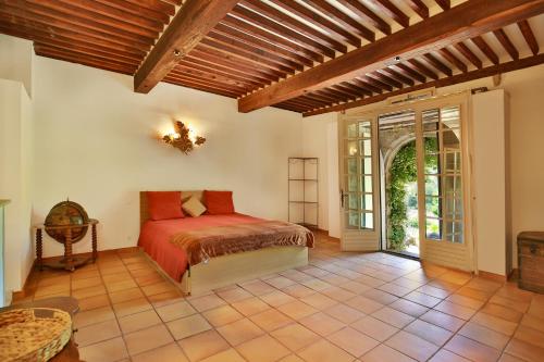 une chambre avec un lit et une porte ouverte dans l'établissement Chambre d'hôtes Les Temps Heureux, à Callian