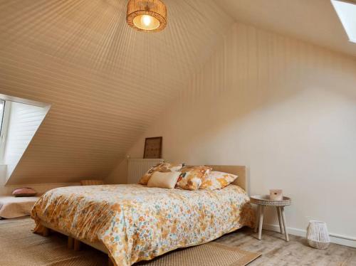 een slaapkamer met een groot bed op zolder bij Maison face au moulin Giverny in Vernon