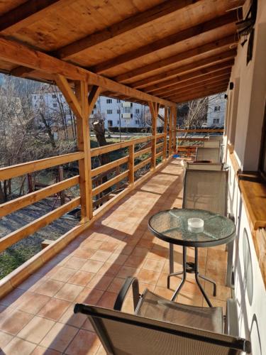 a balcony with a table and chairs on it at Pensiunea Armonia in Băile Herculane