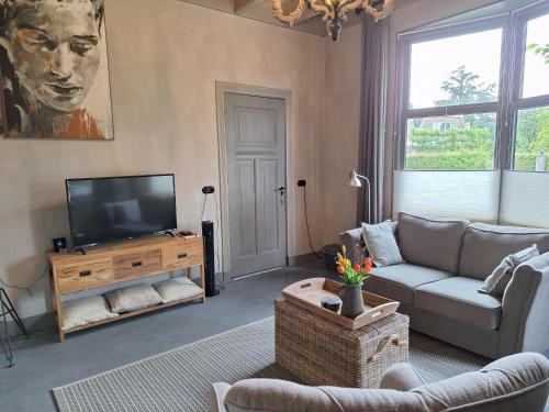 a living room with a couch and a television at B&B De Meidoornhof in Ruinen