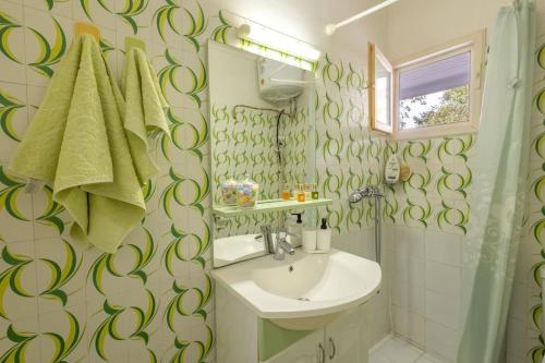 a bathroom with a sink and a shower at Rastoni - Beach Family House in Chorafakia