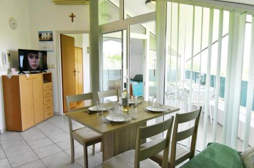 ein Esszimmer mit einem Holztisch und Stühlen in der Unterkunft Beleuchtete Wohnung Eva in Zambratija, Savudrija, nahe dem Strand, mit Balkon mit Meerblick, Klimaan in Savudrija