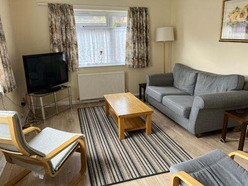 a living room with a couch and a tv at Large Ground floor apartment in the heart of Church Stretton with free parking in Church Stretton