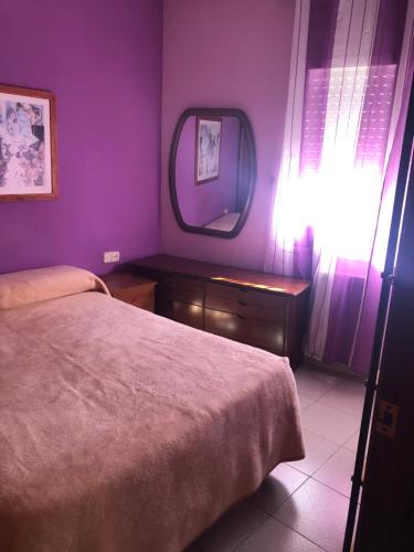 a bedroom with a bed and a mirror on the wall at Habitación IE in Sitges
