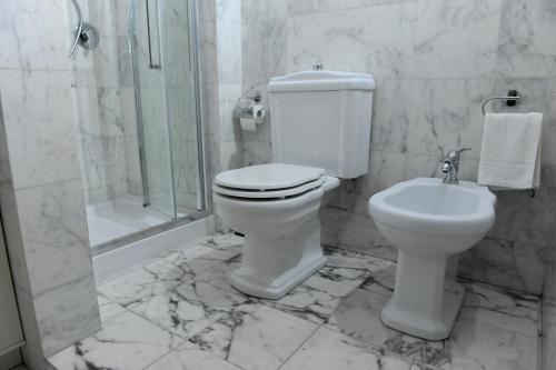 a white toilet sitting in a bathroom next to a sink at ARIA DI CASA APARTMENT in Florence
