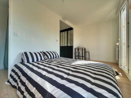 - une chambre avec un lit rayé noir et blanc dans l'établissement Studio refait à neuf avec parking, à Toulouse