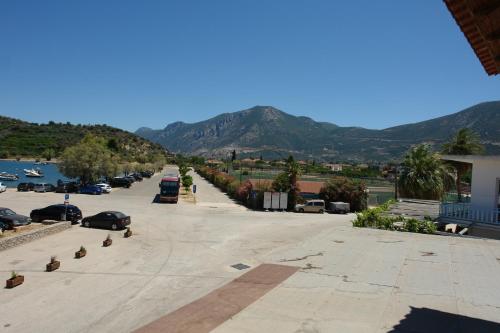 a street with cars parked in a parking lot with mountains at Verdelis Inn in Ancient Epidavros