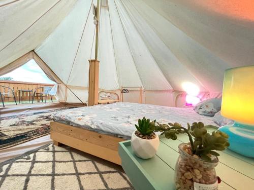 une chambre avec une tente avec un lit et des plantes dans l'établissement Glamping Agapia Agapescu, à Agapia