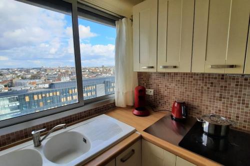 une cuisine avec vue sur une ville depuis une fenêtre dans l'établissement Appartement 2 pièces tres lumineux, à La Garenne-Colombes