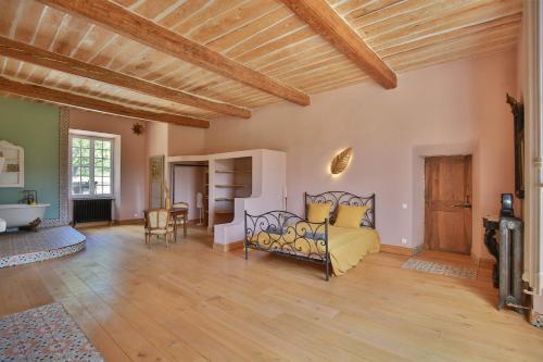 a bedroom with a bed in a room with wooden ceilings at Chambre d'hôtes Les Temps Heureux in Callian