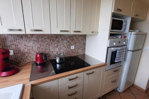 une cuisine avec des armoires blanches et un comptoir noir dans l'établissement Appartement 2 pièces tres lumineux, à La Garenne-Colombes