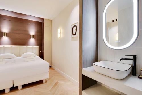 une salle de bain avec un lit, un lavabo et un miroir dans l'établissement New Home - 1BR-4P - Saint Germain, à Paris