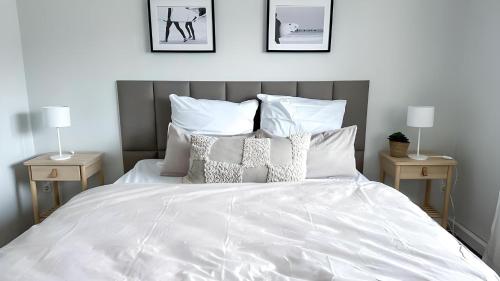 a bedroom with a white bed with two night stands at Business & Leisure Apartment in Ingolstadt