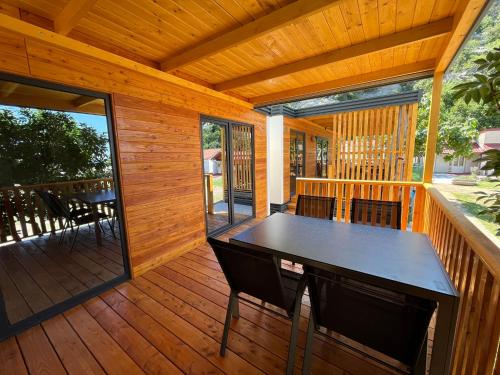 a screened porch with a table and chairs on a deck at MIMOSA Luxury Mobile Homes in Sveti Juraj