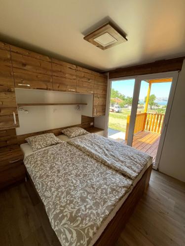 a bedroom with a large bed and a balcony at MIMOSA Luxury Mobile Homes in Sveti Juraj
