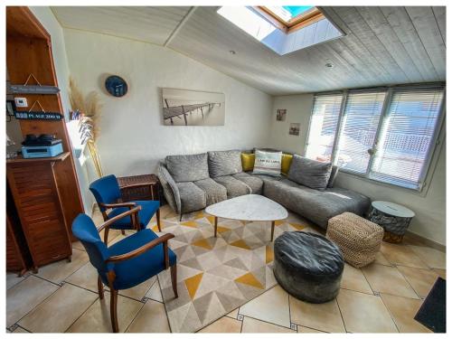 un salon avec un canapé, une table et des chaises dans l'établissement Zen et Cosy - Plage à Pieds - Villa tout confort, à Saint-Hilaire-de-Riez